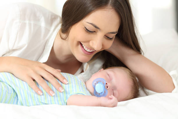istock Mother watching her baby sleeping on a bed 823837458