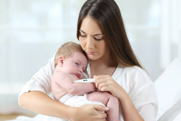 mother using a thermometer with her baby - child fever illness thermometer imagens e fotografias de stock