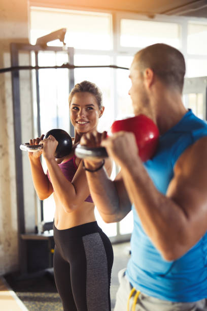 istock Two young athlete people doing kettlebell exercises at gym 823837912