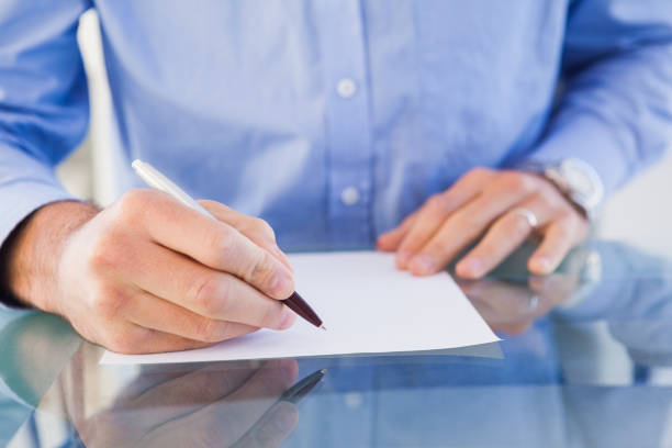 istock Businessman sitting at desk writing 823840194