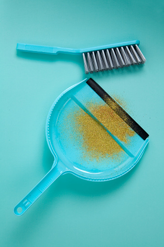 Picking up glitter with brush and dustpan.
