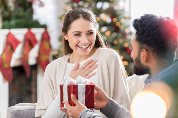 istock Man surprises female friend with Christmas present 823846054