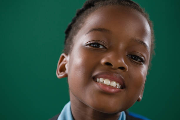 istock Smiling schoolgirl against green background 823846236