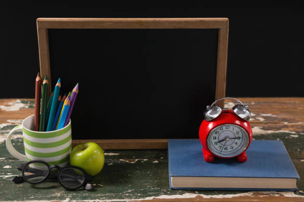 istock Chalkboard with book, pen holder, apple and spectacles 823847720