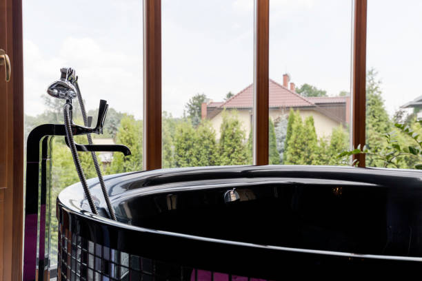 istock Freestanding glossy baththub with garden view 823869930