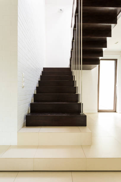 istock Dark wooden stairs in bright corridor 823874356