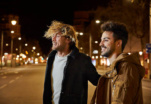 Smiling friends talking while walking on street