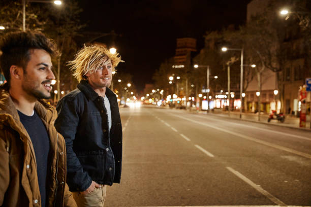 Friends talking while crossing street at night