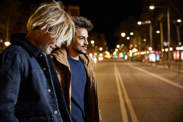 Friends talking while crossing street at night