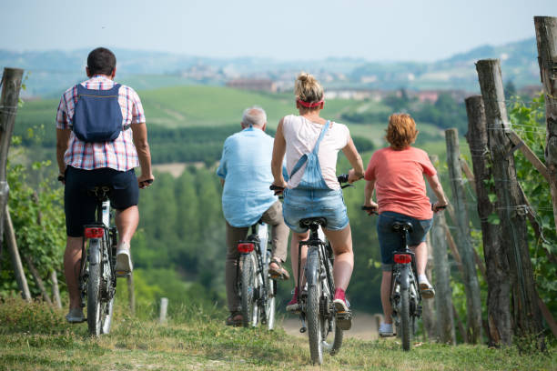 Family holidays in Langhe region, Piedmont, Italy: Electric bikes trip in the hills Family holidays in Langhe region, Piedmont, Italy: Electric bikes trip in the hills agritourism stock pictures, royalty-free photos & images