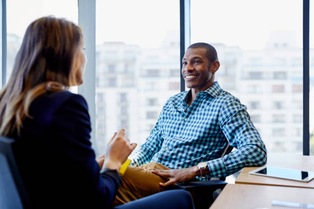 istock Young business people sitting on chairs at office 823877328