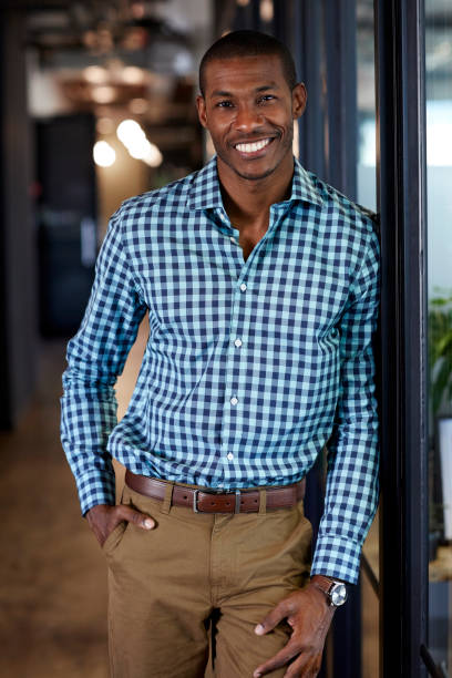 istock Smiling businessman leaning on glass in office 823877700