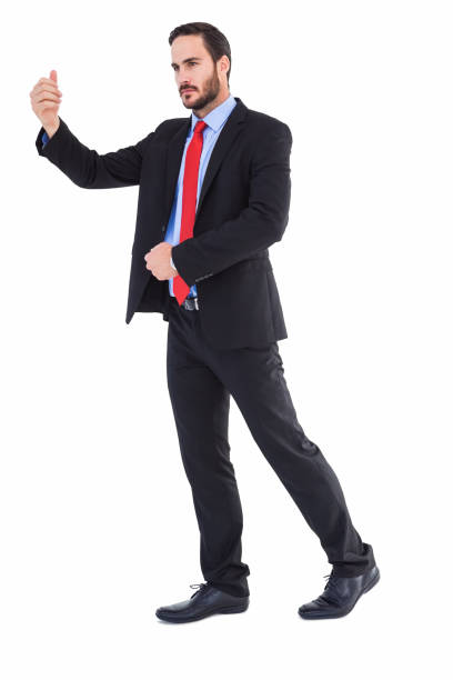 istock Serious businessman standing with arms raised 823898462