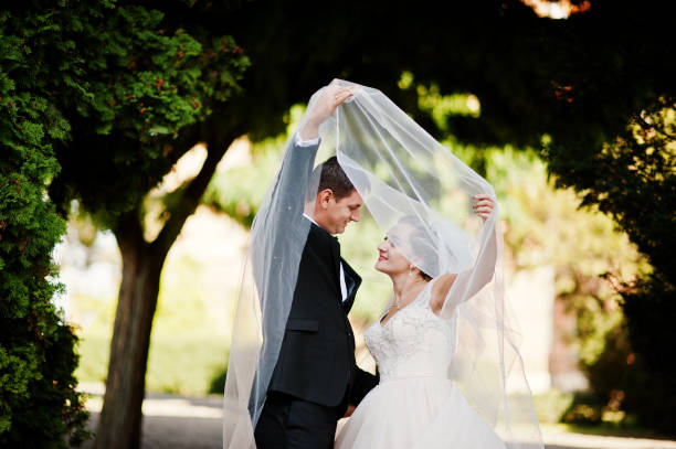 istock Fantastic wedding couple walking in the park on their wedding day. 823910476