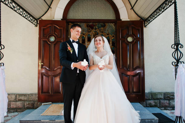 istock Awesome wedding couple releasing doves into the sky. 823917154