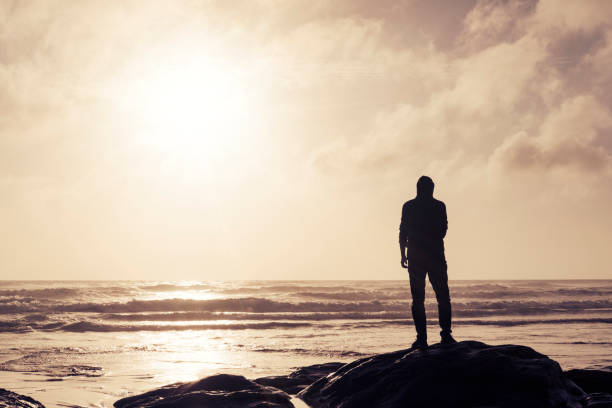 istock Man Stood on a rock looking out over a Sunset. 823917888