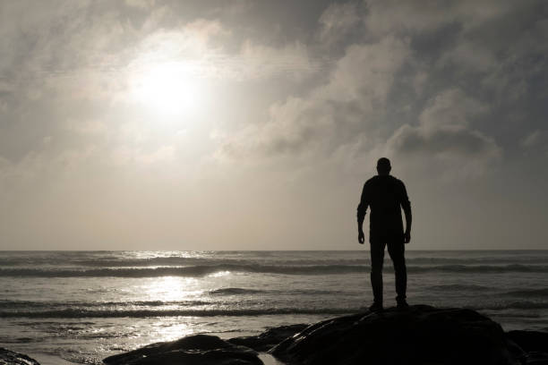 istock Man Stood on a rock looking out over a Sunset. 823917890