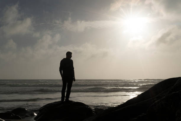 istock Man Stood on a rock looking out over a Sunset. 823917902
