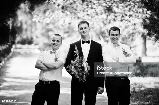 Handsome Groom Walking With His Bestmen Or Groomsmen In The Park On A Wedding Day Black And White Photo Stock Photo - Download Image Now