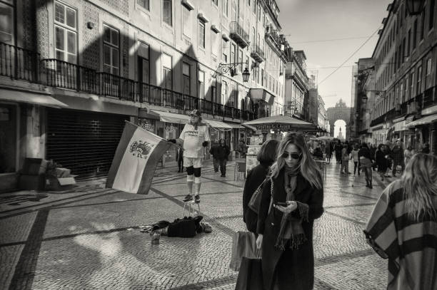 Lisbon, Portugal - November 22, 2016: A man dressed in the Real Madrid outfit and holding a spanish flag, performs as a living statue in the Rua Augusta in Lisbon downtown.