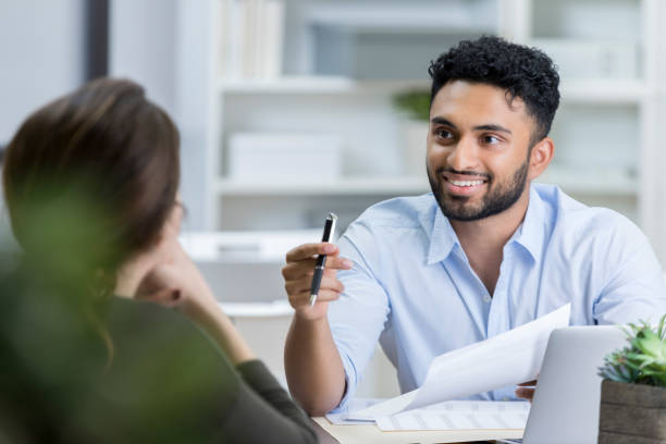 istock Young manager sits across desk as he interviews prospective employee 823927622