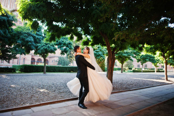 istock Fantastic wedding couple walking in the park on their wedding day. 823927876