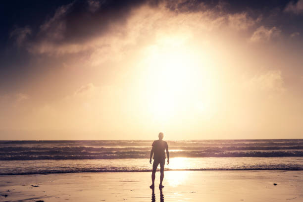 istock Man stood on a Beach near sunset after a run along the beach. 823932150