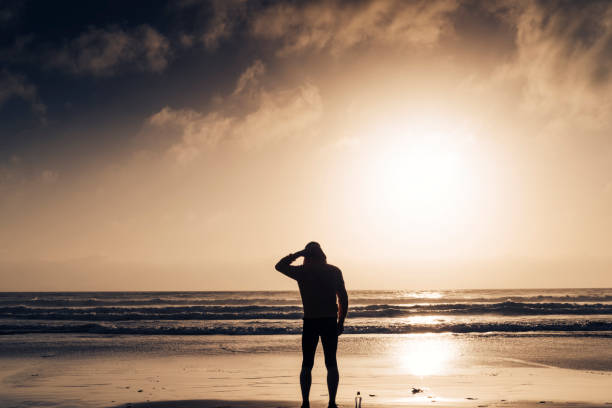 istock Man stood on a Beach near sunset after a run along the beach. 823932228