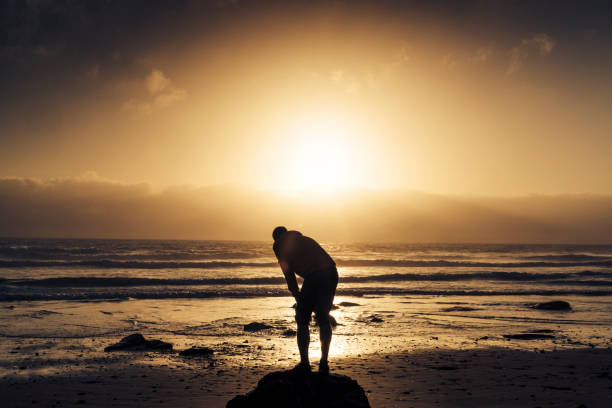 istock Man resting after a run along the beach. 823932274
