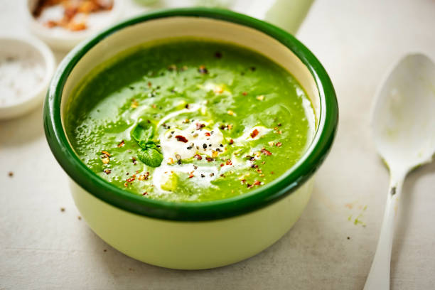 zuppa di crema di piselli agli spinaci di broccoli con crema e scaglie di peperoncino - cream of broccoli foto e immagini stock