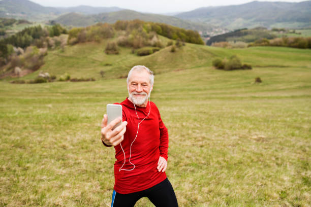 istock Active senior runner in nature taking selfie with smart phone. 823945838
