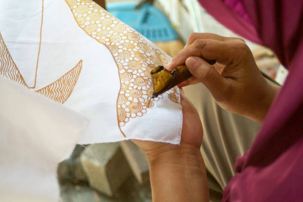 istock indonesian woman making batik design with wax 823945906