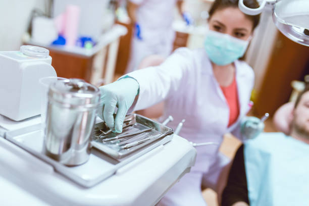 istock Female Dentist With Instruments Examining Young Male Patient 823966362