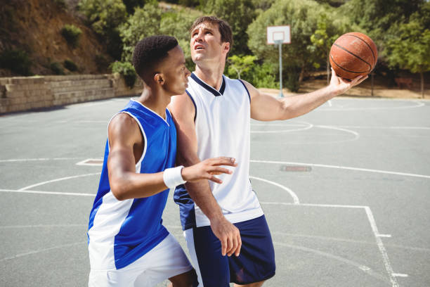 istock Players playing basketball on sunny day 823972824