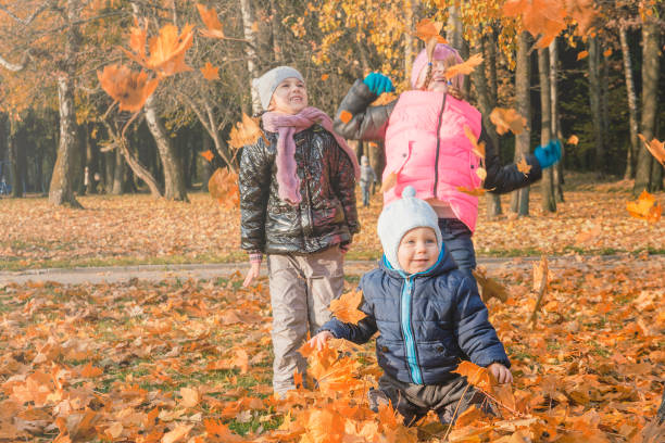 Children play in autumn Park.Falling leaves from trees.