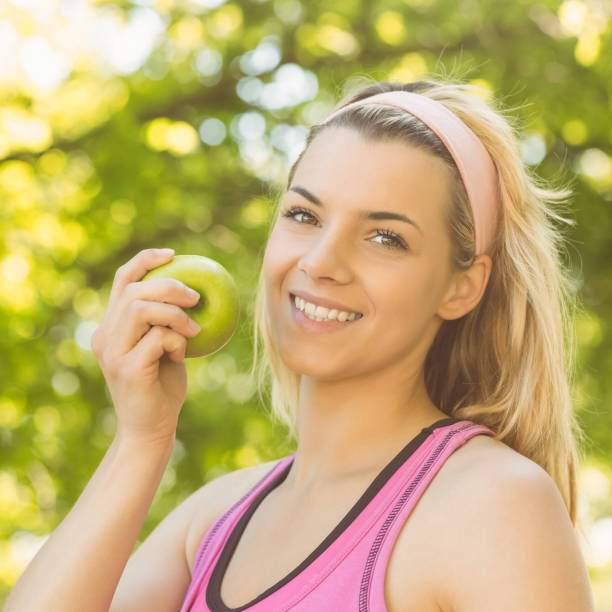 istock Fit blonde holding green apple 823975248