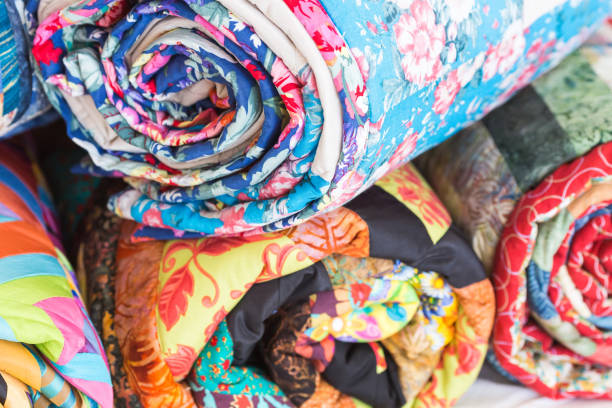 relaxation, coiziness, rest concept. stack from four different rags rolled up into tube has various colors. Top one is blue and decorated by images of flowers and petals