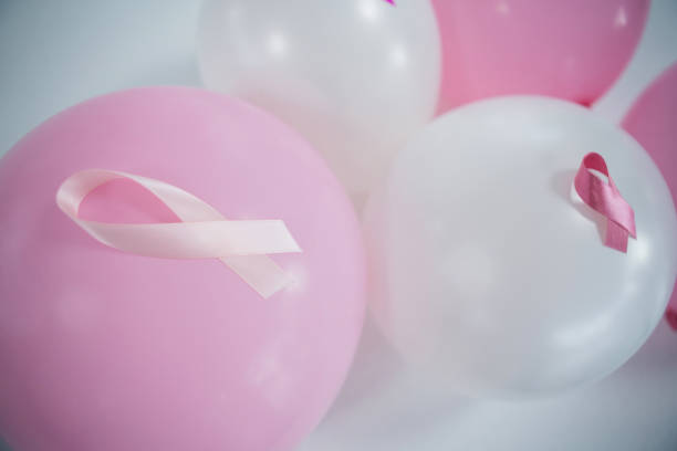 vue de la forte inclinaison de rubans roses de sensibilisation au cancer du sein sur ballons - elementary age focus on foreground indoors studio shot photos et images de collection