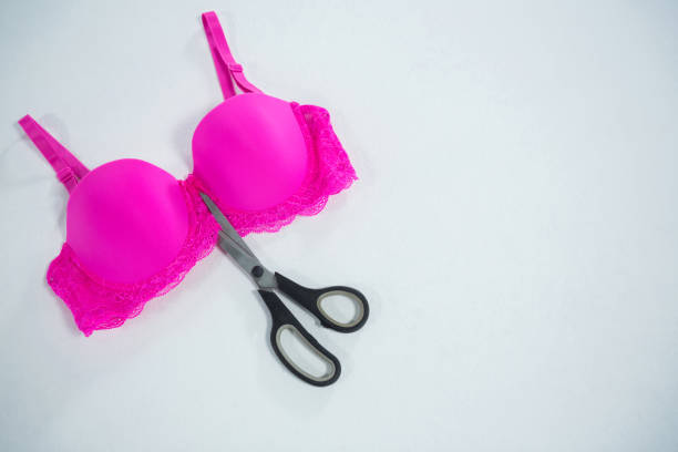 istock High angle view of vibrant pink bra with scissors 823978648