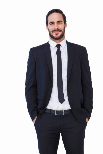 istock Smiling businessman in suit standing with hands in pockets 823985706