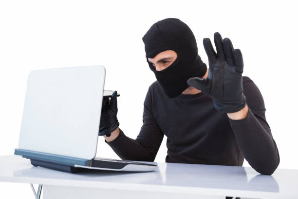istock Focused burglar hacking into laptop 823986378