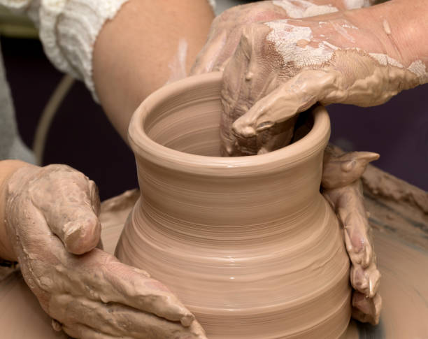 istock Two women in process of making clay vase on pottery wheel 824012828