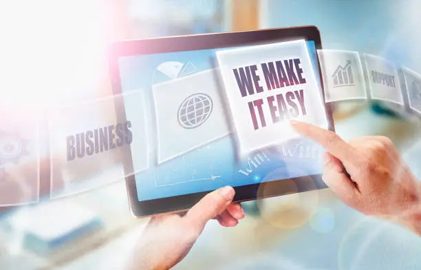 Photo of A businesswoman selecting a We Make it Easy business concept on a futuristic portable computer screen.