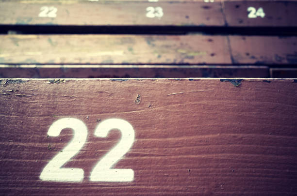 Number twenty two painted on an old wooden seat.