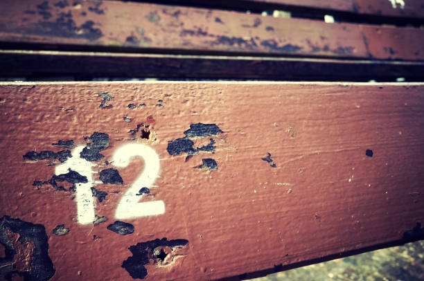 istock Number twelve painted on an old wooden seat. 824017462