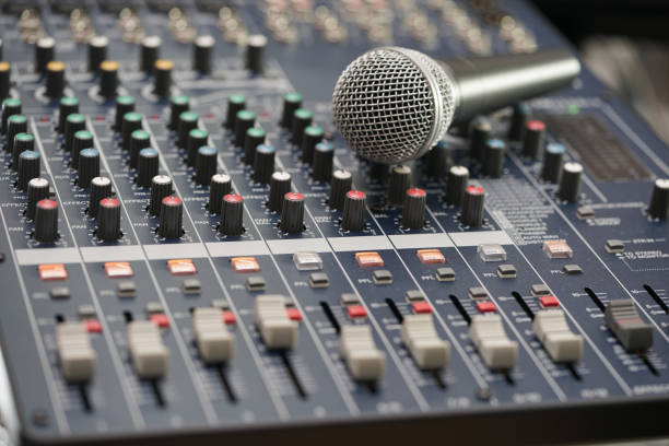 istock Microphone put on the Professional Music Mixer Console with dial knob and slide bar. 824017714