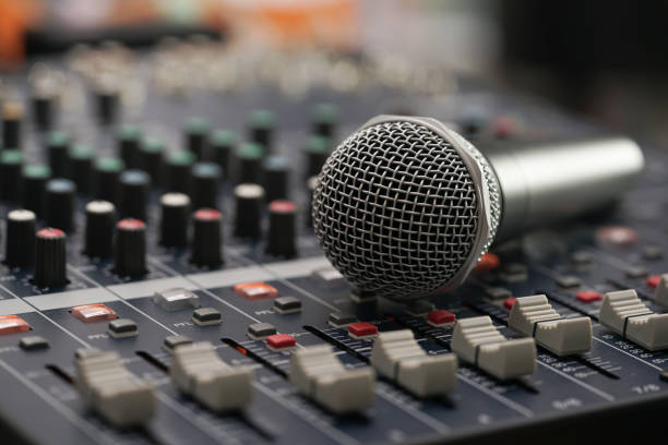 istock Microphone put on the Professional Music Mixer Console with dial knob and slide bar. 824017806
