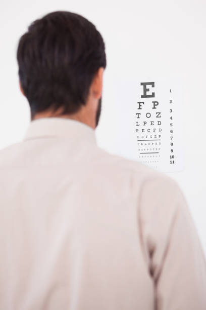 istock Focused man in suit on eye test letters 824027502