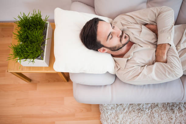 istock Man sleeping on the couch with arms crossed 824027670
