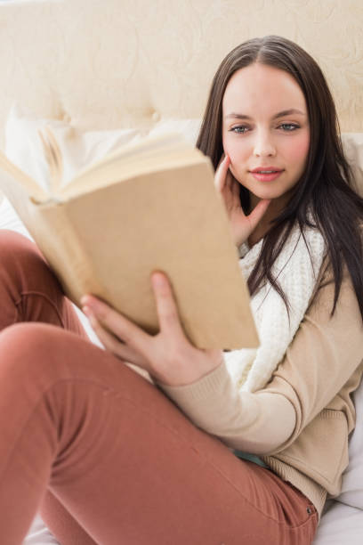 istock Pretty brunette reading on her bed 824029992